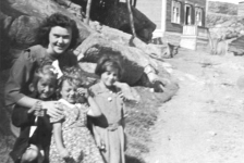 070: Cede McCarthy with three young pupils. l-r Mary Ennis, Betty Whelan,  Rosemary Whelan. (circa 1944) Tom Rose's house is in the background; Pat Lambe's  flake is at left; the road up Lambe's hill is between the flake and the house;  the 'gallus' is in the center.  - Mary daughter of Vincent Ennis &amp;amp; Min Carroll; Betty and Rosemary daughters of William  Whelan &amp;amp; Mary Bridget Carroll